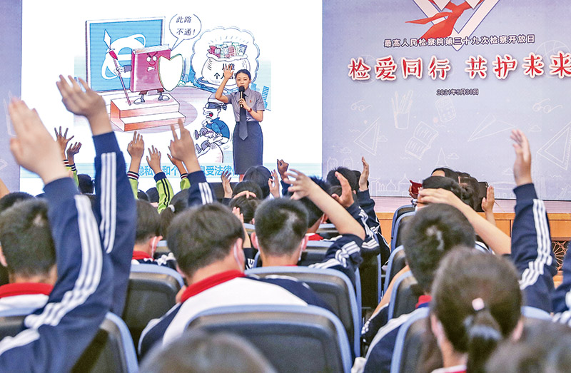 2021年5月30日，在新修訂的未成年人保護法和預防未成年人犯罪法即將正式施行之際，最高人民檢察院舉辦以&ldquo;檢愛同行 共護未來&rdquo;為主題的檢察開放日活動。圖為在開放日活動的法治教育課上，工作人員與學生互動。　新華社記者 殷剛/攝